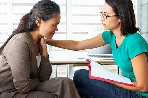 A woman in a therapy session, speaking with her therapist about morphine addiction treatment.
