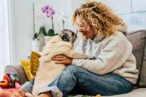 person playing with adorable pug in pet friendly rehab