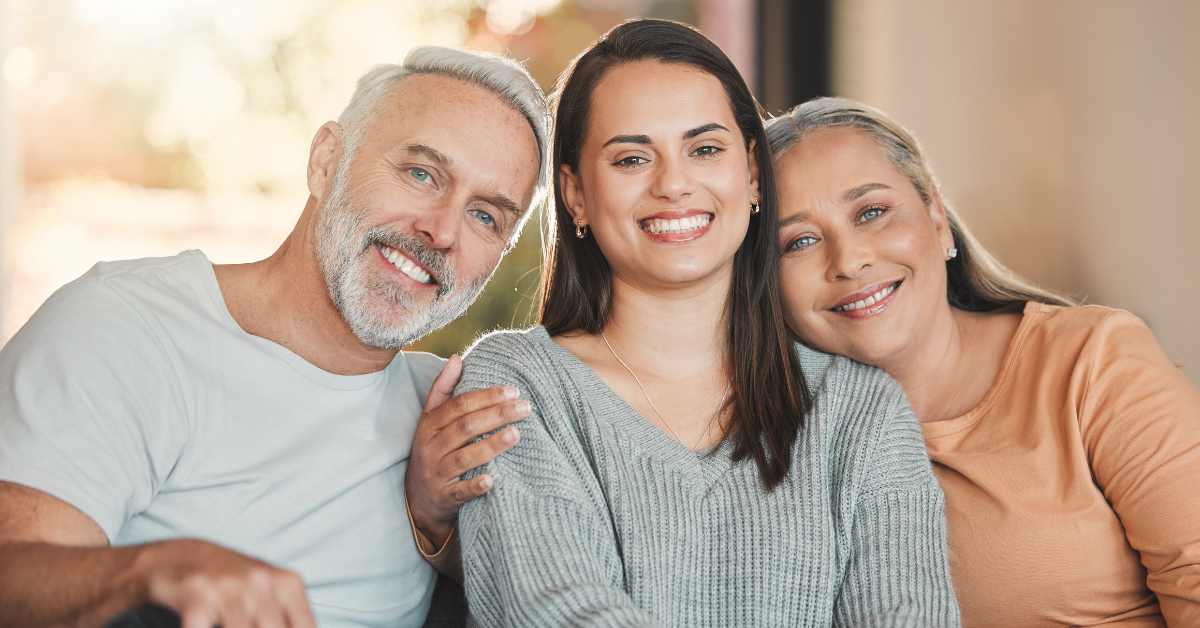 father, adult daughter, and mother in family therapy, posing together