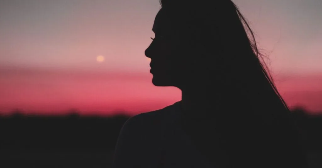 Silhouette of a woman at sunset symbolizes hope and strength in outpatient addiction recovery for bipolar disorder and addiction at Crest View Recovery.