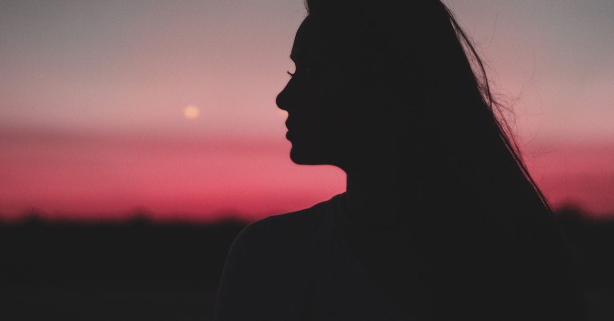 Silhouette of a woman at sunset symbolizes hope and strength in outpatient addiction recovery for bipolar disorder and addiction at Crest View Recovery.