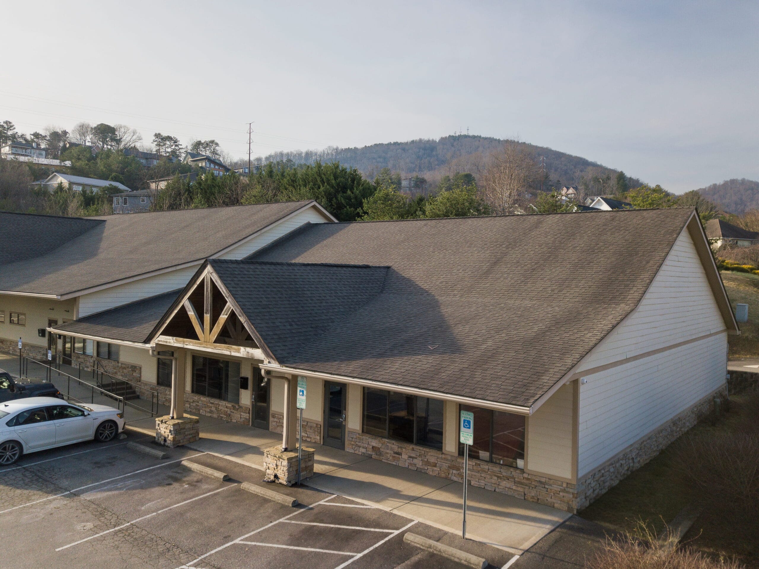 Crest View Recovery Center’s single-story Asheville facility with stone, wood, and large windows offers inviting addiction treatment.