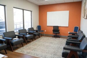 Crest View Recovery Center group therapy room in Asheville, NC with circle of chairs, whiteboard, bright windows for outpatient addiction treatment.